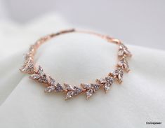 This dainty bracelet has cubic zirconia stones in leafy shape.  It measures approximately 5 1/2" long with 1 1/2" extender chair for additional length. The width is about 5/16" just over 1/4". This is perfect addition for your vintage style wedding.  It also makes a perfect gift for your bridal party or someone special!  The length is adjustable upon request up please check with me if you need a longer length. Perfect piece for a glamorous bride!   Coordinating necklaces, https://www.etsy.com/li Elegant Rose Gold Cubic Zirconia Diamond Bracelet, Rose Gold Cubic Zirconia Bracelet, Dazzling Rose Gold Cubic Zirconia Bracelet, Luxury Rose Gold Cubic Zirconia Bracelet, Gold-tone Cubic Zirconia Bracelet, Jewelry Rose Gold, Cubic Zirconia Bracelet, Bracelet Wedding, Rose Gold Bridal