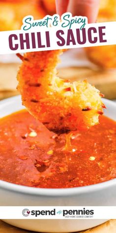 a person dipping chili sauce into a bowl