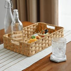 a wicker basket sitting on top of a wooden table next to a glass cup