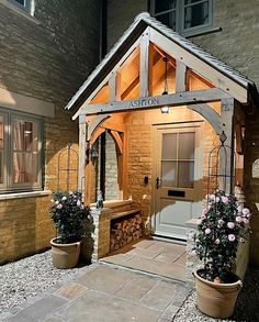 a small wooden building with potted plants outside