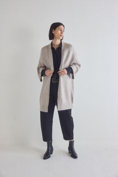 Crafted from premium knit fabric, this kimono-style cardigan wraps you in luxurious softness. Its relaxed yet structured silhouette offers a cozy feel without compromising on style, making it the perfect layering piece for any season. Loose fit Oversized fit Oversized sleeve Side pockets Chic Soft Texture Cardigan For Loungewear, Oversized Soft Outerwear For Layering, Chic Fall Kimono For Daywear, Soft Knit Open Front Loungewear Outerwear, Chic Fall Kimono For Loungewear, Cozy Open Front Cardigan For Layering, Chic V-neck Sweater Coat In Soft Knit, Chic Fall Loungewear Kimono, Chic V-neck Sweater Coat For Layering