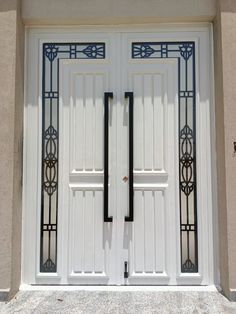 two white doors with decorative iron work on them