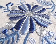 an embroidered blue and white cloth with flowers on it