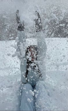 a person laying down in the snow with their feet up and hands out to the side