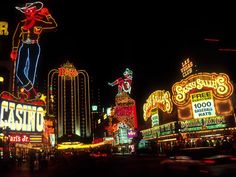 the las vegas strip is lit up at night with neon signs and buildings in the background