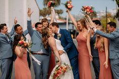 a group of people standing next to each other in front of a building holding flowers