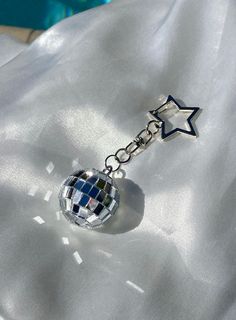 a keychain with a disco ball and star charm hanging from it's side