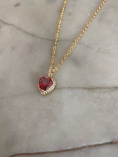 Ruby red heart jewel pendant with a crystal paved bail measuring 1.8 cm x 1 cm. Hung on a gold-plated chain which measures 45.7 cm (18 inches). Comes in a black velvet cushioned box. As seen in last photo. Free of charge. INTERNATIONAL BUYERS please choose the tracking option if you would like your order to be tracked. FREE tracking upgrade with 3 items or more purchased. JEWELLERY CARE please don't wear plated jewellery in the shower, bath or swimming for the plating to last longer. Red Gemstone Heart Cut Necklace, Red Heart Cut Necklace For Formal Occasions, Red Gemstone Heart Pendant Necklace, Elegant Red Gemstone Heart Necklace, Formal Valentine's Day Gold Plated Heart Necklace, Red Heart Pendant For Formal Occasion, Red Heart Pendant Necklace For Party, Red Heart Jewelry For Formal Occasions, Red Heart Cut Necklace For Party