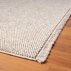 a close up of a rug on a wooden floor with wood floors and white carpet