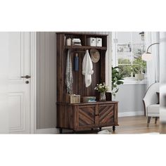 a wooden cabinet sitting in front of a window next to a white chair and potted plant