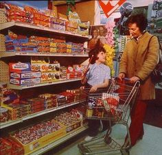 an older woman pushing a shopping cart with a young child in it at a grocery store