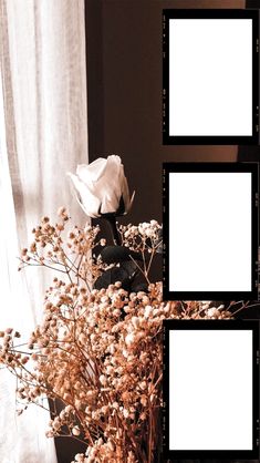 a vase filled with flowers next to two empty frames