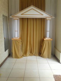 an empty room with yellow drapes on the windows and white tile flooring in front of it