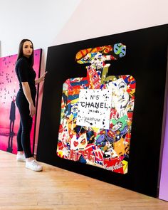 a woman standing in front of a chanel advertisement