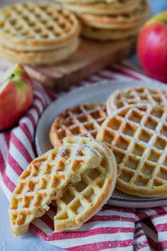 three waffles on a plate with apples in the background