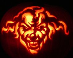 a carved pumpkin with an evil clown face on it