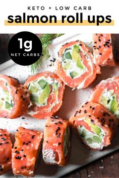 salmon roll ups with avocado and cucumber in the middle on a white plate