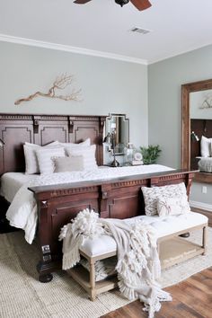 a bedroom with a bed, mirror, and bench in it's centerpiece