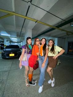 four girls are posing for the camera in a parking garage