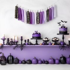 a table topped with lots of purple and black cakes