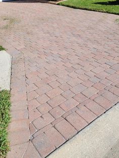 a red fire hydrant sitting on the side of a brick road in front of a house