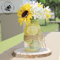 a mason jar filled with lemons and daisies