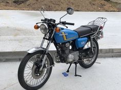 a blue and black motorcycle parked on the street