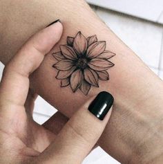 a woman's arm with a flower tattoo on the left side of her wrist