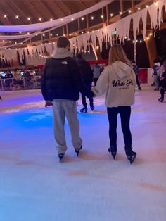 two people are skating on an ice rink