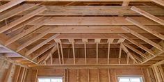 the inside of a house being built with wood framing on the ceiling and windows in the room