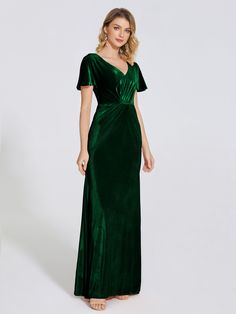 a woman wearing a green velvet gown with short sleeves and a v - neckline