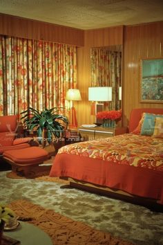 the bedroom is decorated in orange and yellow colors with floral drapes on the windows