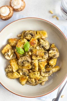 a white bowl filled with pasta and mushrooms