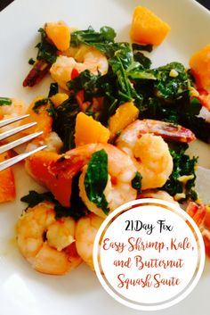 a white plate topped with shrimp, spinach and carrots next to a fork