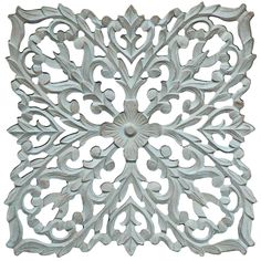 an intricately carved design on the side of a white wall mounted plaque ornament