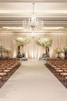 the aisle is lined with clear chairs and tall centerpieces filled with pink flowers