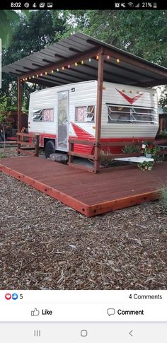 a mobile home sits in the middle of a wooded area with lights strung over it