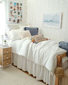 a bedroom with white bedding and string lights