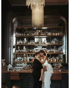 a man and woman standing in front of a bar with liquor bottles on the shelves