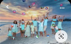 a group of people standing on top of a beach next to the ocean with balls in the air