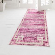 a pink area rug in front of a white door