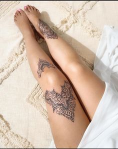 a woman laying on top of a bed covered in tattoos