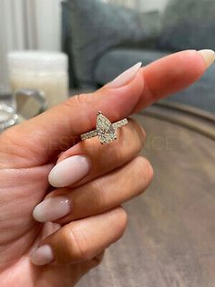 a woman's hand holding a ring with a star on the middle of it