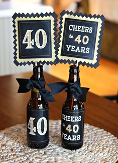 two beer bottles are decorated with black ribbon and bow for 40 years anniversary party decorations