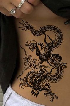 a woman's stomach with a dragon tattoo on it