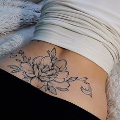 a woman with a flower tattoo on her stomach