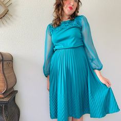 "Fantastic late 70s to 80s vintage dress in vibrant teal green blue. Love the gorgeous voluminous sheer sleeves, ruffled tiered neckline, elastic waist, and crimp pleated skirt with funky texture toward the hem flares out to A-line shape. So light, and floaty with tons of movement and playful details! Vintage made in the USA by the brand Jenny. Has string belt loops but missing original belt. Tagged size 12, suits about a modern medium. Measures Bust, pit to pit 20\"  Elastic waist 12\" relaxed Vintage Ruffled Dress For Fall Party, Spring Billowy Midi Dress For Party, Spring Party Vintage Pleated Dress, Fall Party Dresses With Accordion Pleats, Vintage Dresses With Sheer Sleeves For Spring, Retro Ruffled Dresses For Fall, Retro Pleated Dress For Fall, Retro Flowy Party Dress, Flowy Retro Party Dress