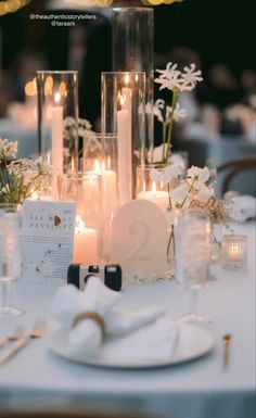 the table is set with candles, plates and napkins for an elegant wedding reception