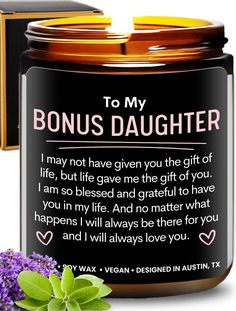 a candle that says to my daughter on the front and back of it, next to some flowers