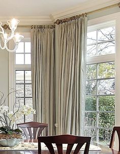 a dining room table with four chairs and a chandelier hanging from the ceiling